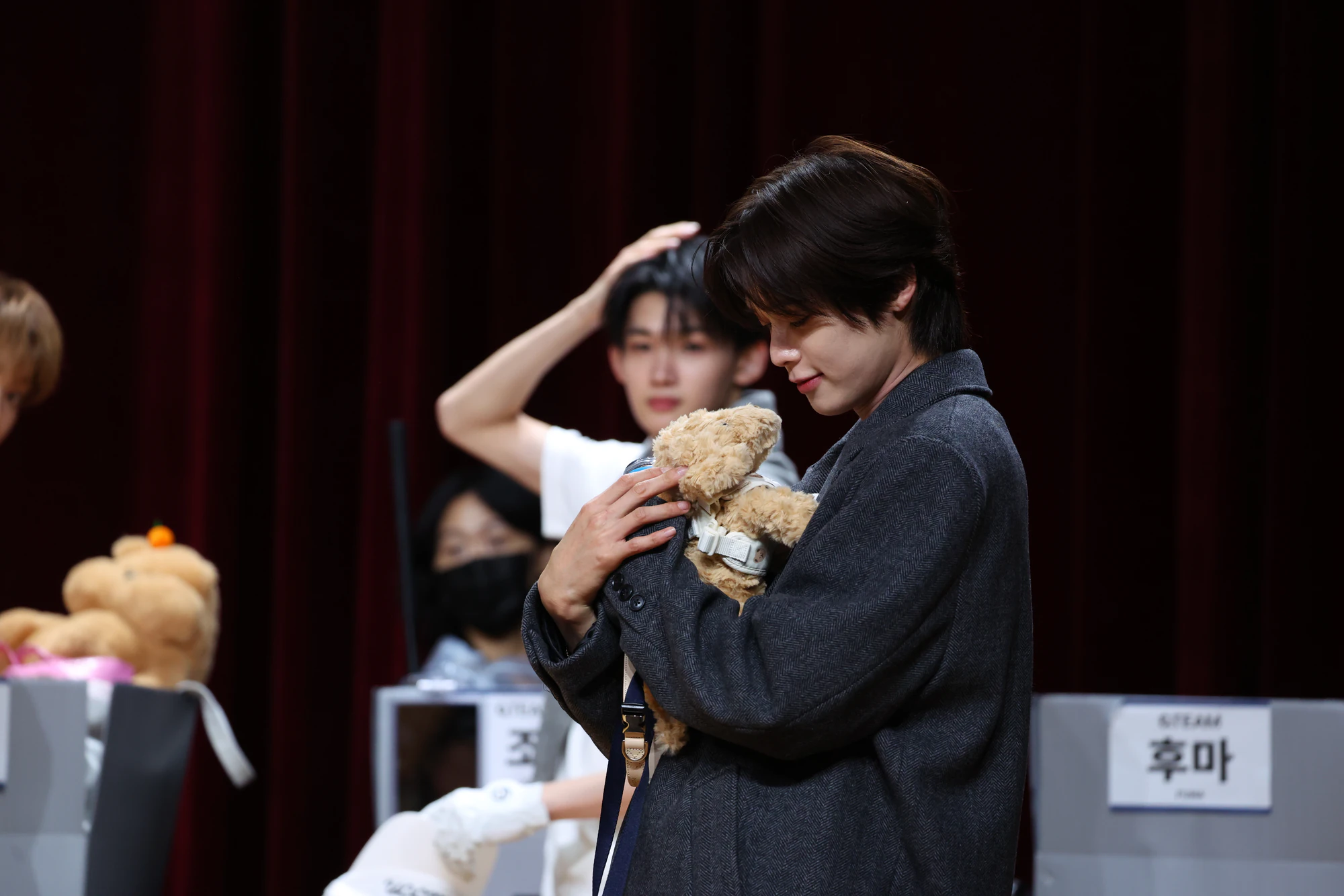 K holding a small gift during an audience event.